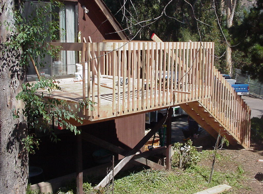 A newly built second-story deck along the side of a house