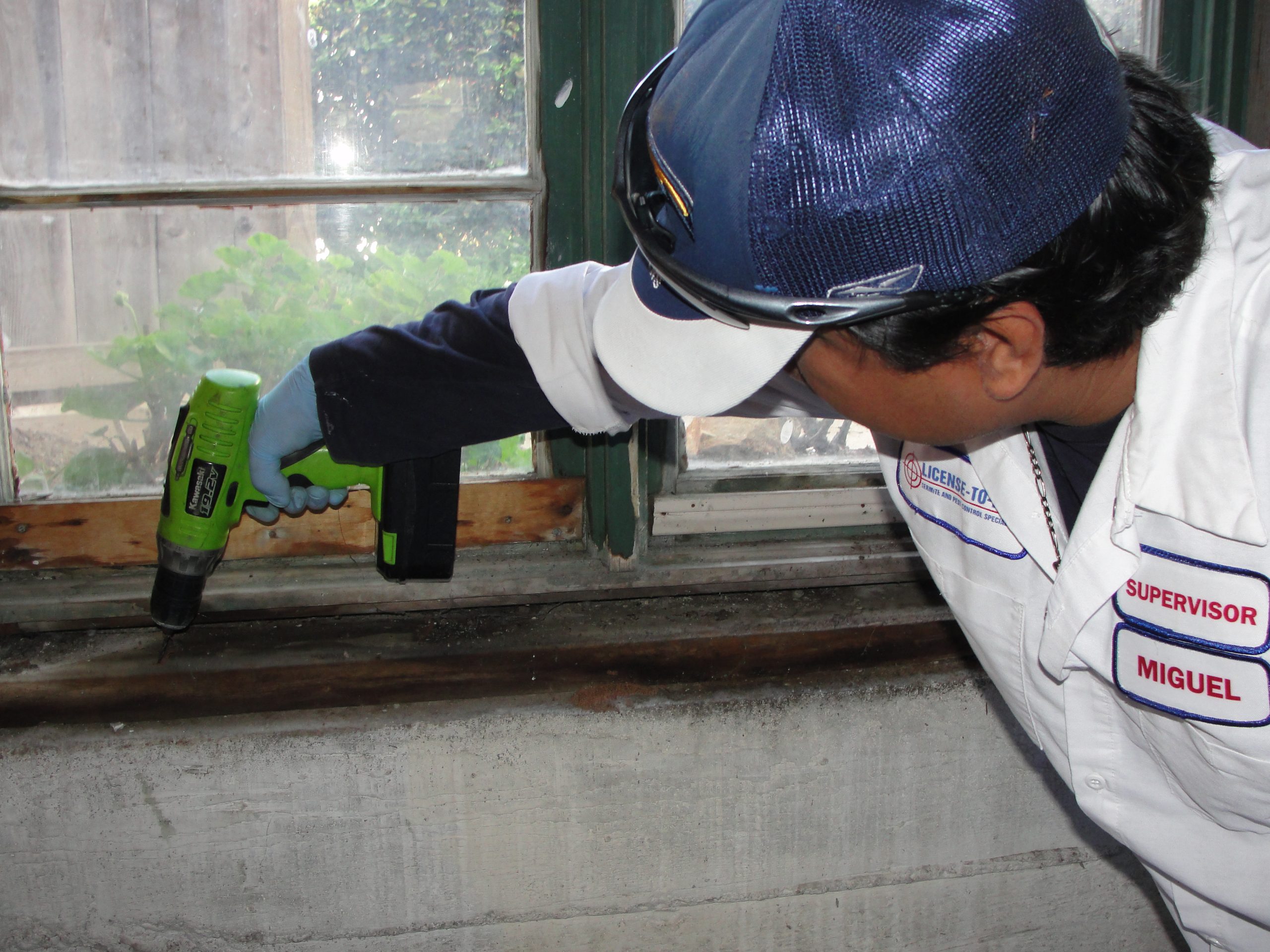 Supervisor Miguel using a drill on a window