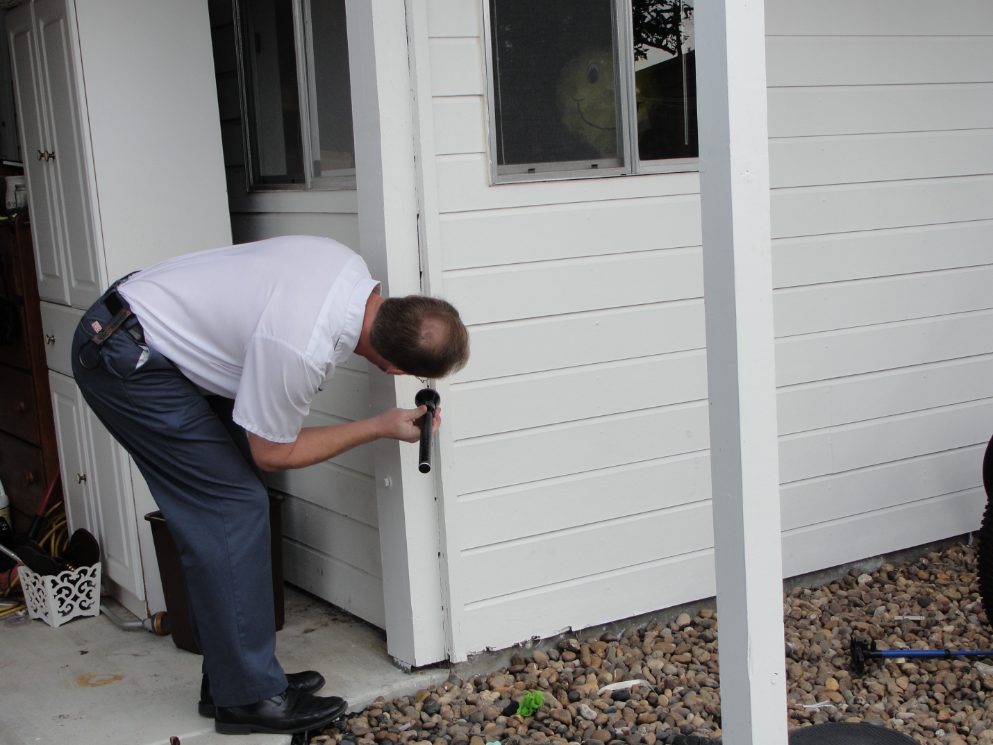 A professional inspecting a house for termite infestation